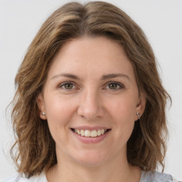 Joyful white young-adult female with medium  brown hair and green eyes