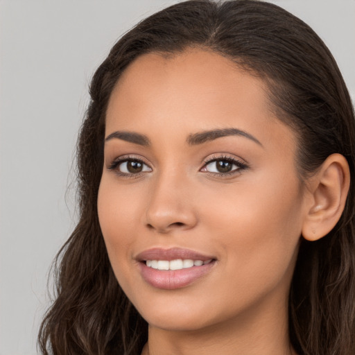 Joyful white young-adult female with long  brown hair and brown eyes