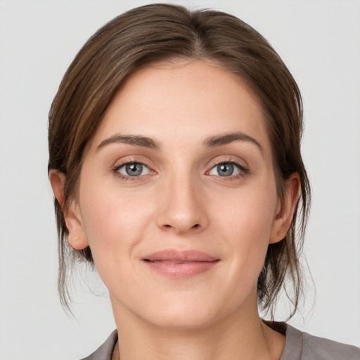 Joyful white young-adult female with medium  brown hair and grey eyes