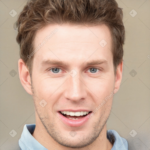 Joyful white young-adult male with short  brown hair and grey eyes