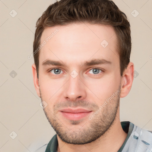 Joyful white young-adult male with short  brown hair and grey eyes