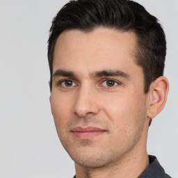 Joyful white young-adult male with short  black hair and brown eyes