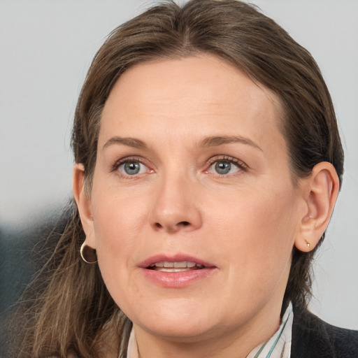 Joyful white adult female with medium  brown hair and grey eyes