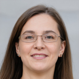 Joyful white adult female with long  brown hair and grey eyes