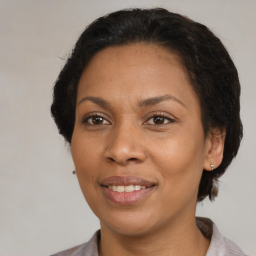 Joyful black adult female with medium  brown hair and brown eyes