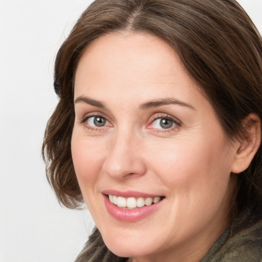 Joyful white adult female with medium  brown hair and grey eyes