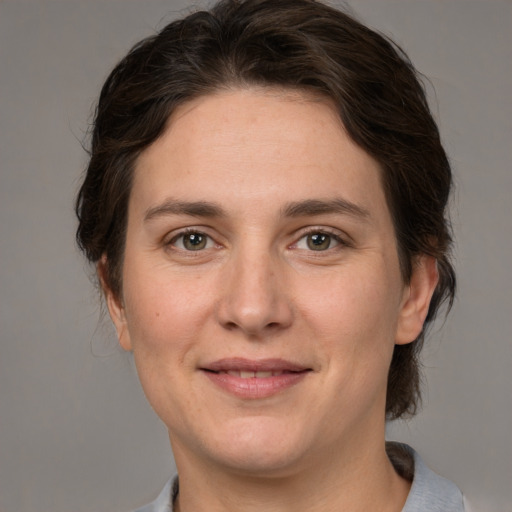 Joyful white adult female with medium  brown hair and grey eyes