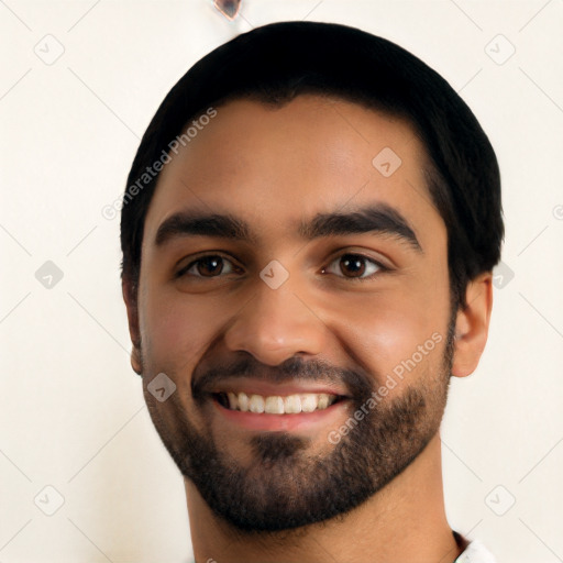 Joyful latino young-adult male with short  black hair and brown eyes