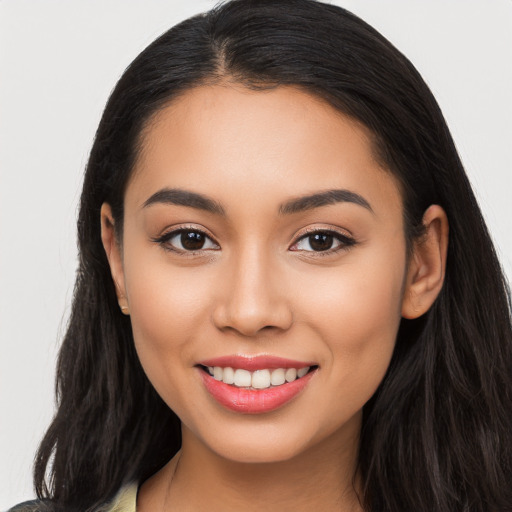 Joyful latino young-adult female with long  black hair and brown eyes