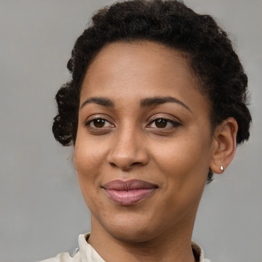 Joyful black young-adult female with short  brown hair and brown eyes