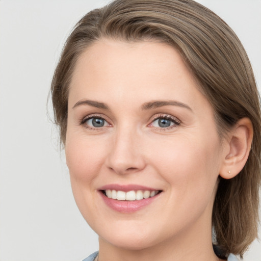 Joyful white young-adult female with long  brown hair and grey eyes