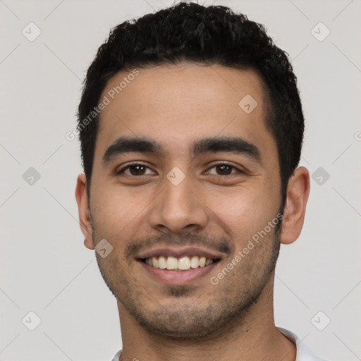 Joyful latino young-adult male with short  black hair and brown eyes