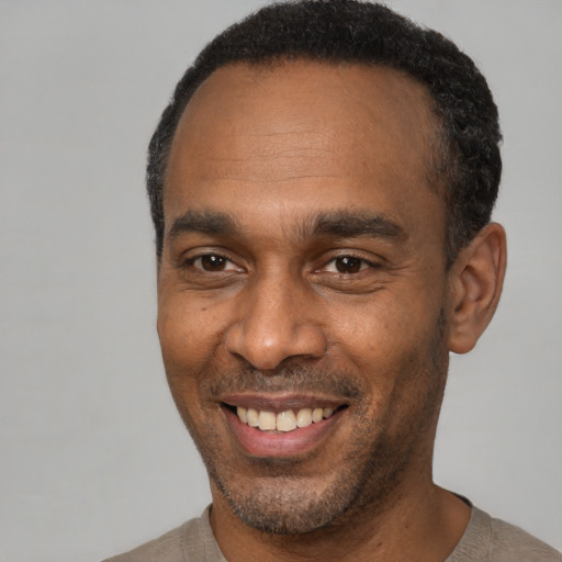 Joyful latino adult male with short  black hair and brown eyes