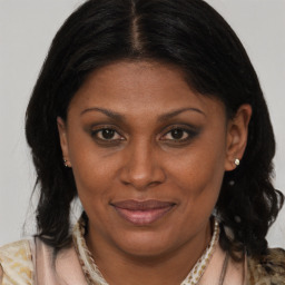 Joyful black adult female with medium  brown hair and brown eyes