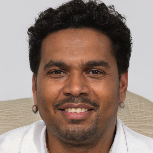Joyful black young-adult male with short  brown hair and brown eyes