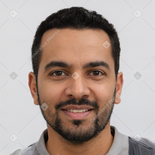 Joyful latino young-adult male with short  black hair and brown eyes