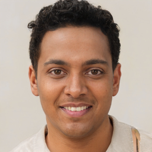 Joyful latino young-adult male with short  brown hair and brown eyes