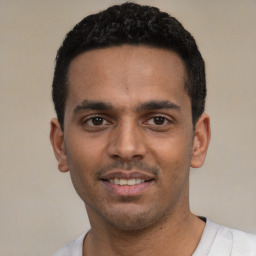 Joyful white young-adult male with short  black hair and brown eyes