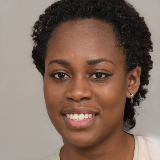 Joyful black young-adult female with long  brown hair and brown eyes