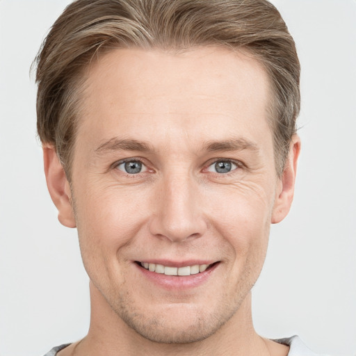 Joyful white adult male with short  brown hair and grey eyes