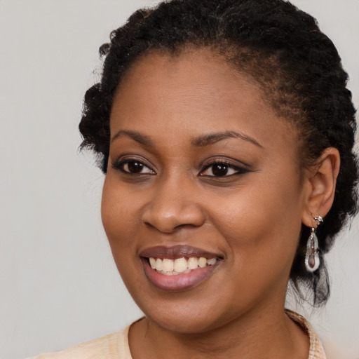 Joyful black young-adult female with long  brown hair and brown eyes