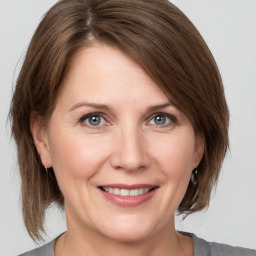 Joyful white adult female with medium  brown hair and grey eyes