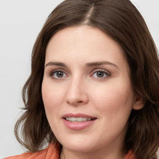 Joyful white young-adult female with medium  brown hair and grey eyes