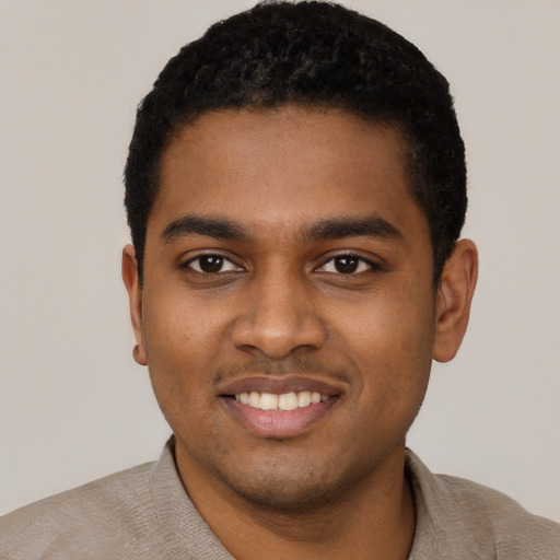 Joyful black young-adult male with short  black hair and brown eyes