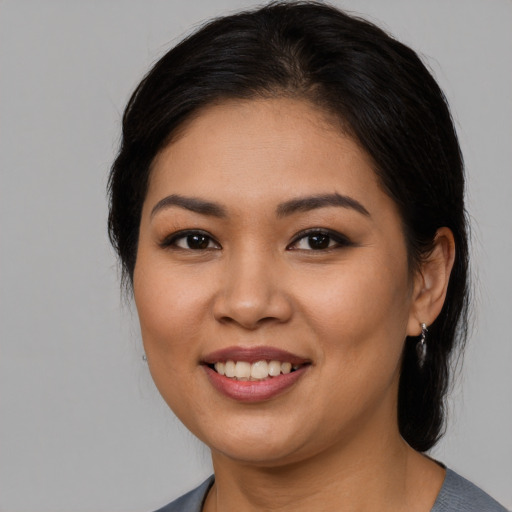 Joyful latino young-adult female with medium  brown hair and brown eyes
