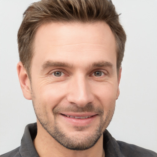 Joyful white young-adult male with short  brown hair and grey eyes