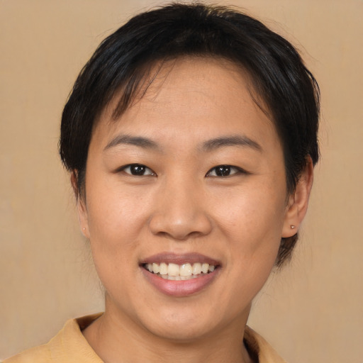 Joyful asian young-adult female with short  brown hair and brown eyes