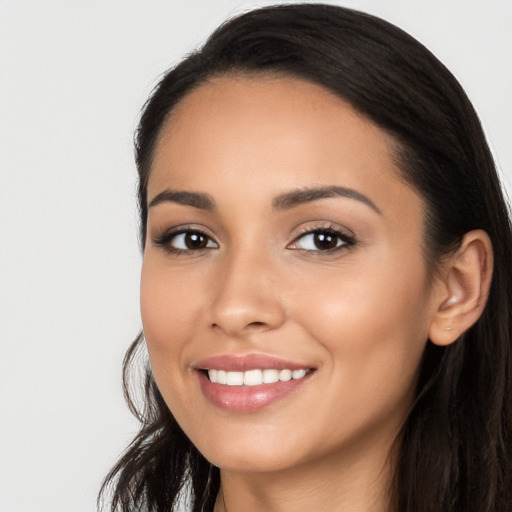 Joyful latino young-adult female with long  black hair and brown eyes