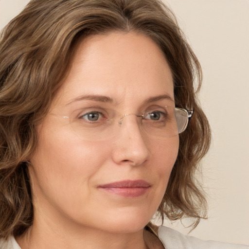 Joyful white adult female with medium  brown hair and green eyes