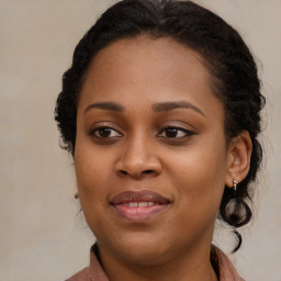 Joyful black young-adult female with long  brown hair and brown eyes