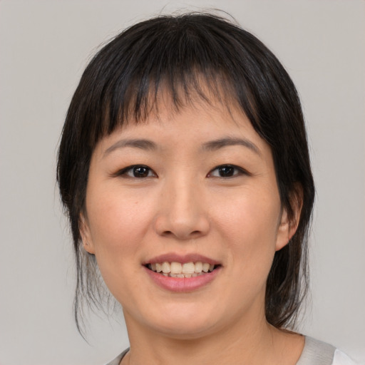 Joyful asian young-adult female with medium  brown hair and brown eyes