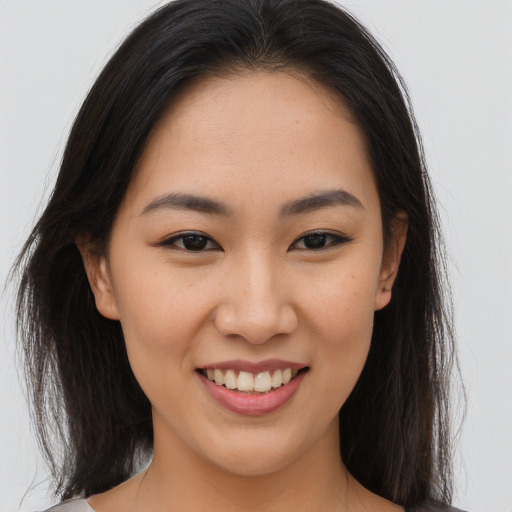 Joyful asian young-adult female with long  brown hair and brown eyes