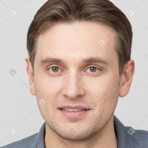 Joyful white young-adult male with short  brown hair and grey eyes