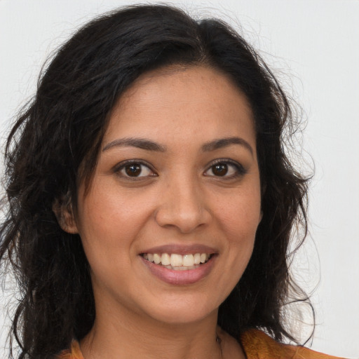 Joyful latino young-adult female with long  brown hair and brown eyes