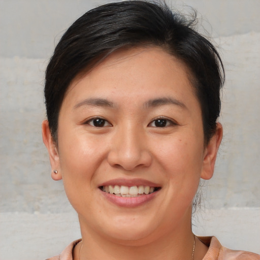 Joyful asian young-adult female with short  brown hair and brown eyes
