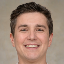 Joyful white adult male with short  brown hair and grey eyes