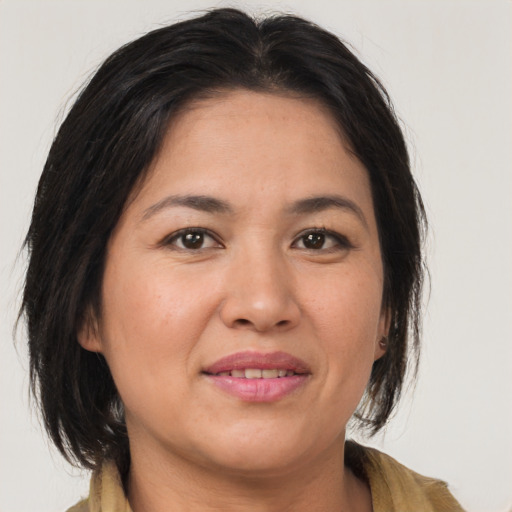 Joyful asian adult female with medium  brown hair and brown eyes