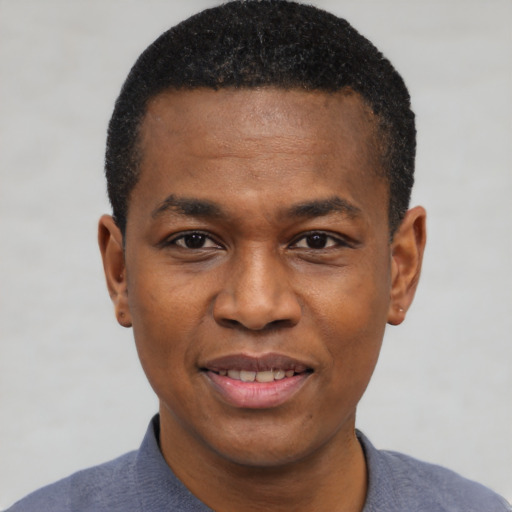 Joyful black young-adult male with short  black hair and brown eyes