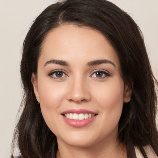 Joyful white young-adult female with long  brown hair and brown eyes