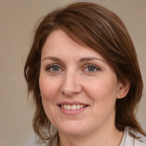 Joyful white adult female with medium  brown hair and blue eyes