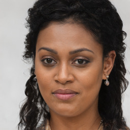 Joyful black young-adult female with long  brown hair and brown eyes