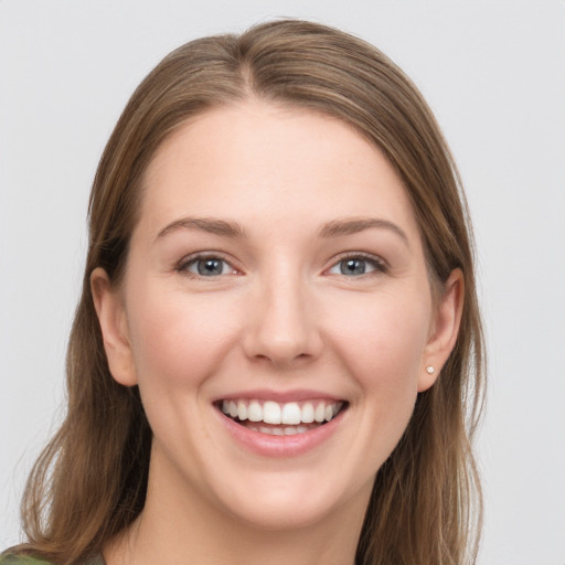 Joyful white young-adult female with long  brown hair and grey eyes