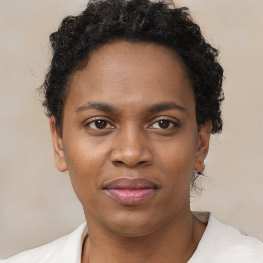 Joyful black young-adult female with short  brown hair and brown eyes