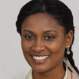 Joyful black young-adult female with long  brown hair and brown eyes