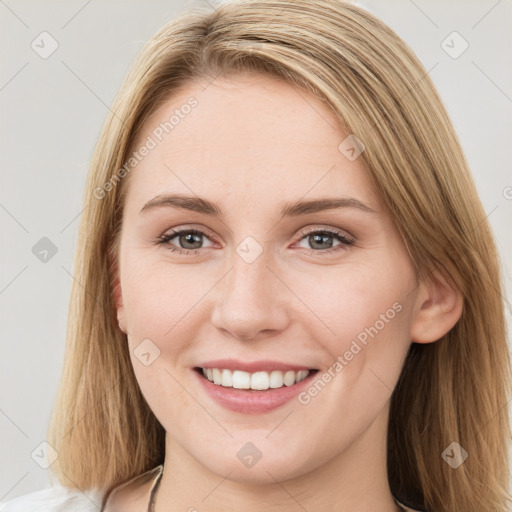 Joyful white young-adult female with long  brown hair and blue eyes