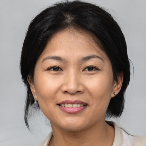 Joyful asian adult female with medium  brown hair and brown eyes